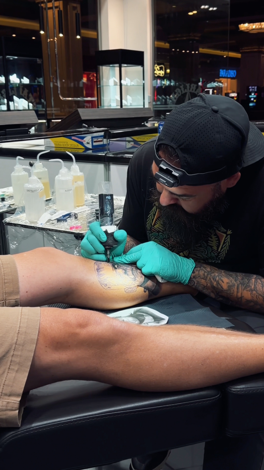 Tattoo artist working on a client at the studio